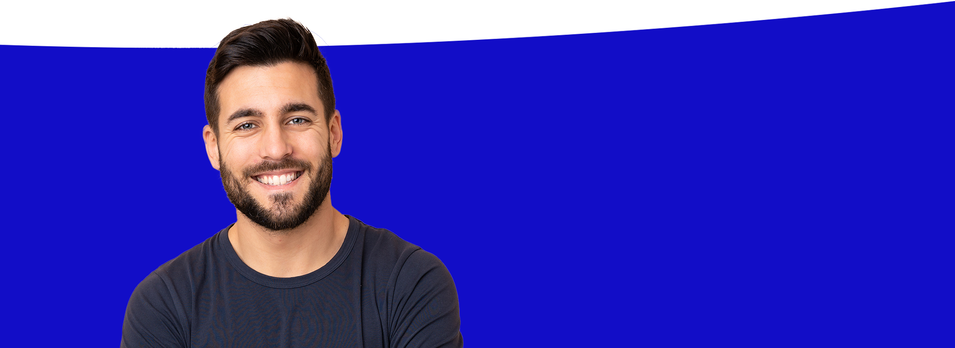 The image features a man with facial hair smiling at the camera, standing against a blue background.