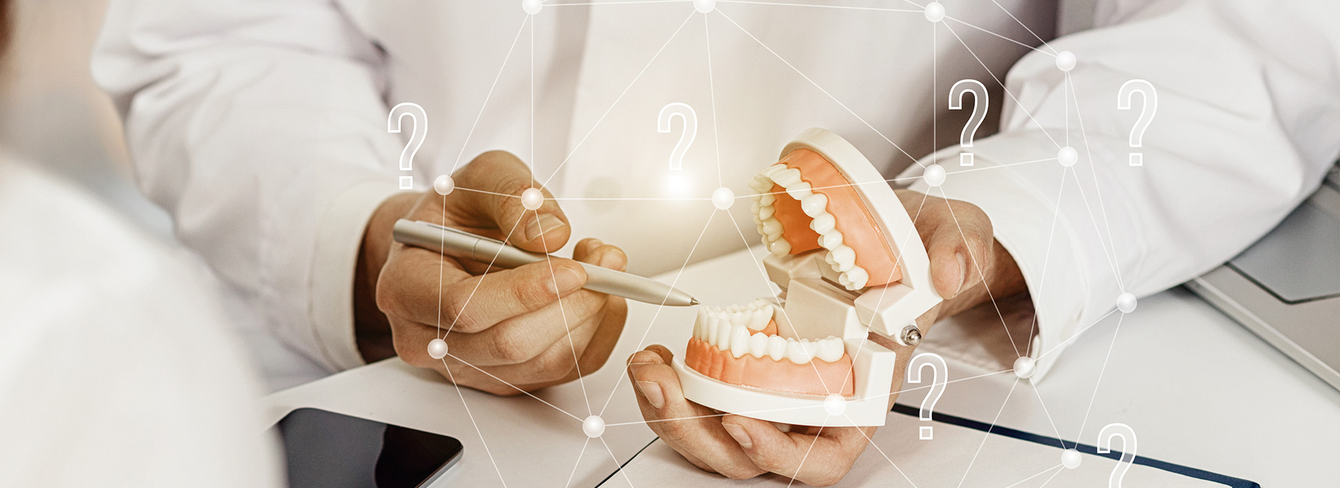 The image shows a person s hand holding a set of dental implants, with a digital interface overlaying the scene, displaying various icons and numbers, suggesting a technical or medical context.