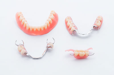 Three pairs of dentures displayed against a white background.