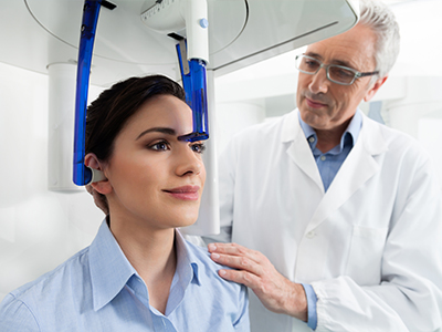 A medical professional assisting a patient with a head scanner, demonstrating the device s operation.